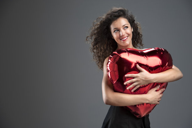 梦想女孩抱着一颗大大的红心。彩色图像图片下载