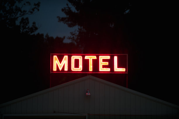汽车旅馆的标志在黑暗中，发光的红色霓虹灯图片下载