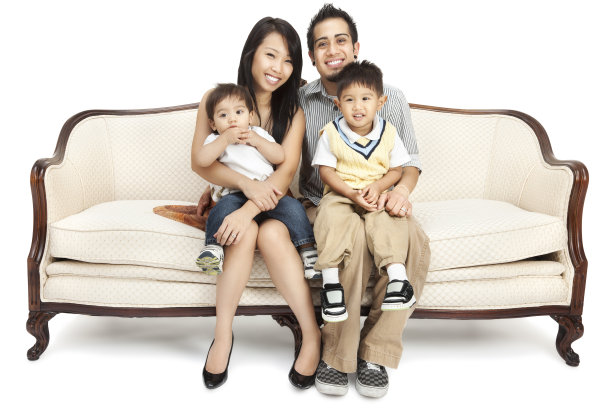 亚洲四口之家坐在古董沙发上图片下载