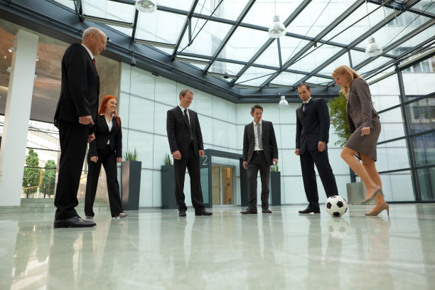 商务人士在大厅踢足球图片下载
