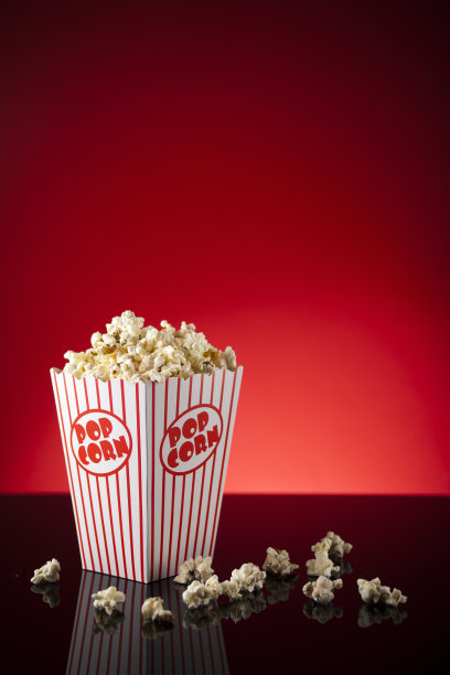 红色背景和反光表面的爆米花盒图片下载