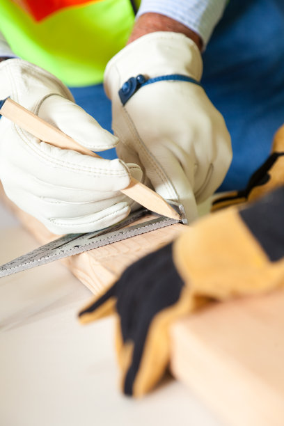 建筑工人的手测量木材的特写图片下载