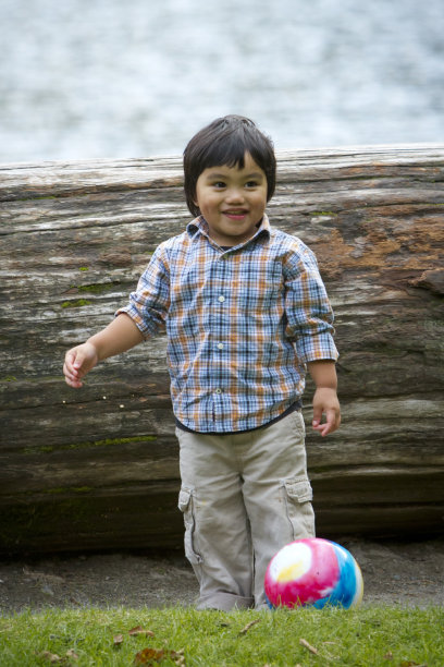 小男孩在湖边玩球。图片下载