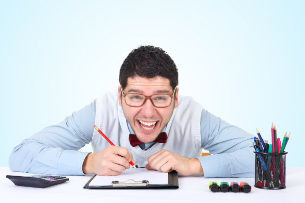 快乐的书呆子商人坐在办公室写作图片下载