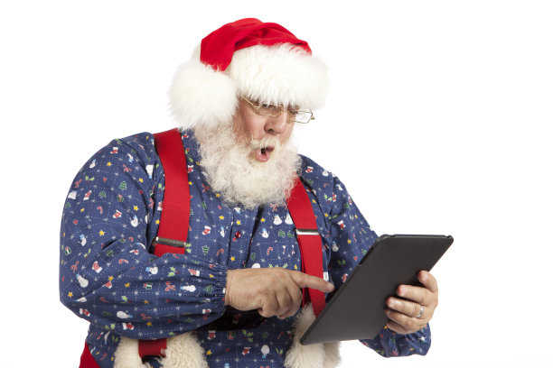真正的圣诞老人检查电子平板电脑的照片图片下载
