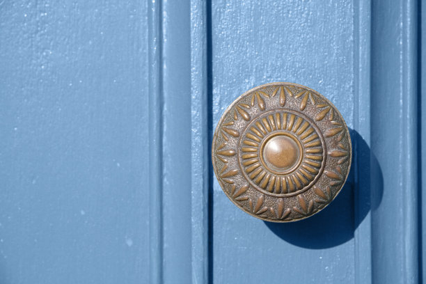 蓝色门上的旧铜门把手素材图片