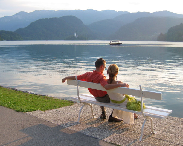 一对相爱的情侣坐在湖边图片下载