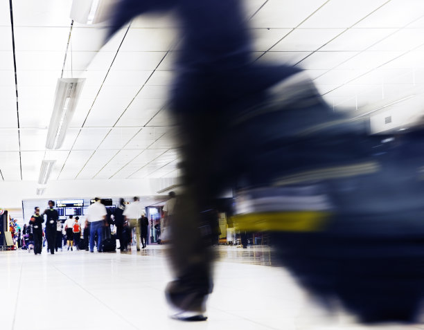 一名男子冲过繁忙的机场大厅图片下载
