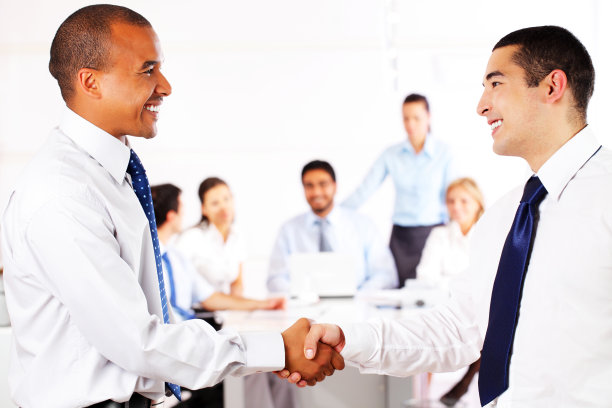 商人们在办公室握手。素材图片