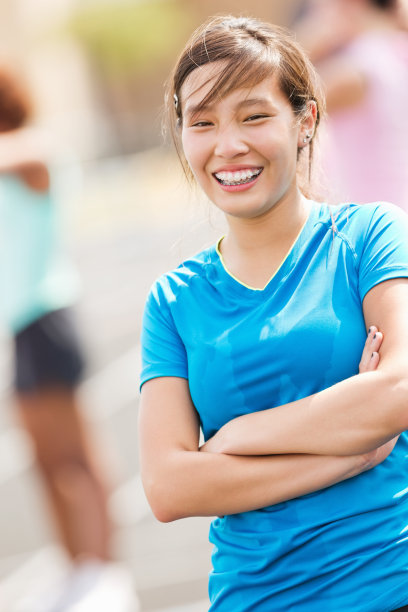 亚洲高中女孩微笑后跑在田径运动会图片下载