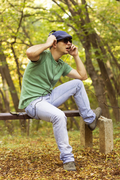 微笑随意的家伙在手机上听音乐图片下载