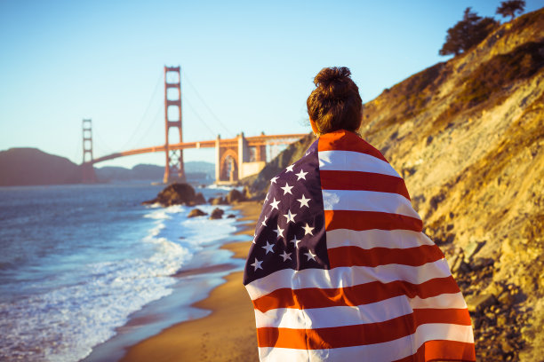 年轻女子覆盖美国国旗和金门大桥图片下载