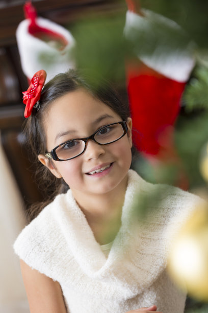 可爱的亚洲女孩在家的圣诞树前图片下载