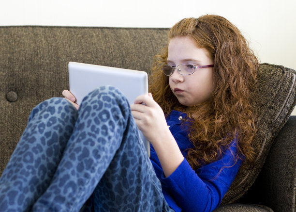 女孩专注于她的平板电脑图片下载