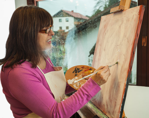 在工作室里作画的成熟艺术家图片下载