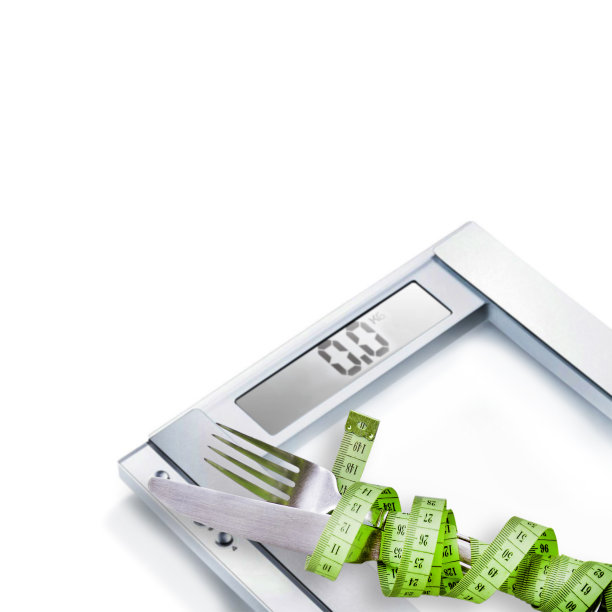 饮食的概念。刀叉放在秤上。图片下载