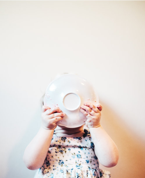 用盘子盖脸的婴儿进食图片下载