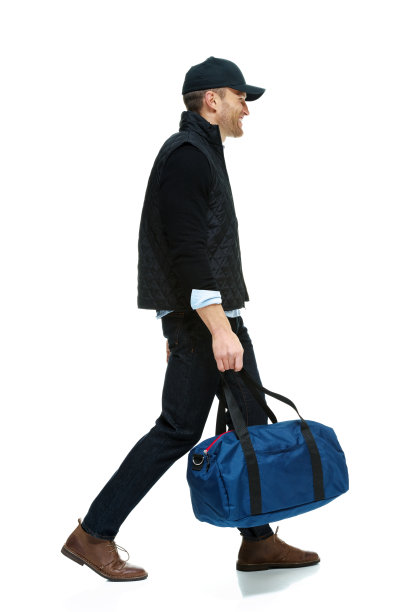 微笑随意的男人拿着运动包走着图片下载