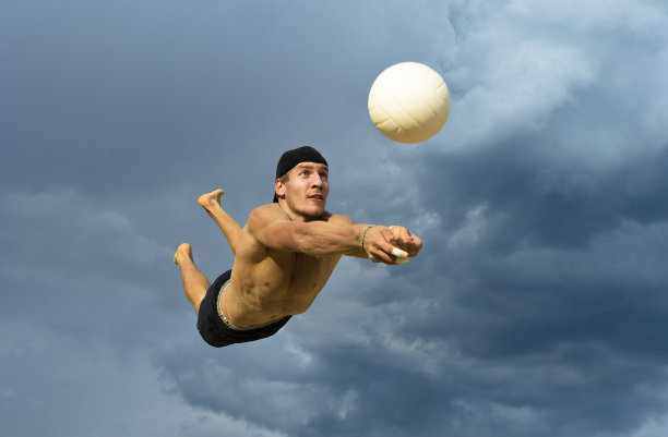 男子排球运动员在吸引人的动作对抗多云的天空图片下载
