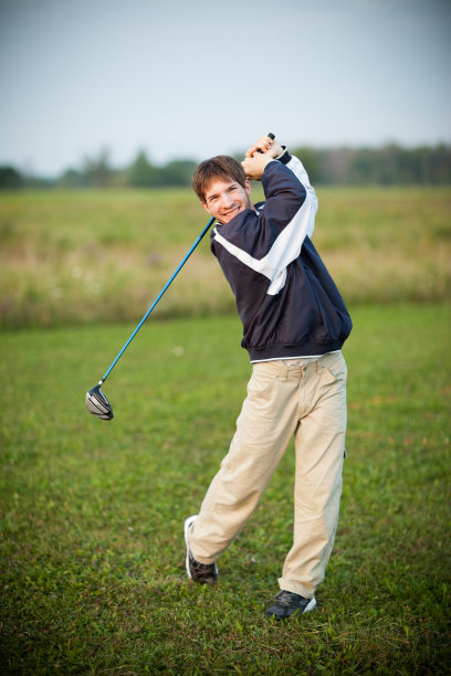 十几岁的男孩在户外挥动高尔夫俱乐部的彩色图像图片下载