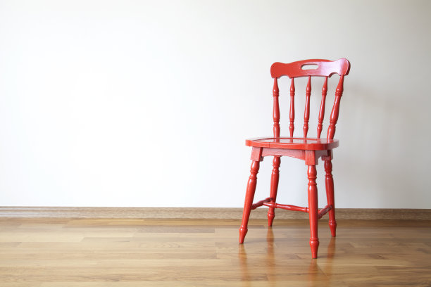 一张空白墙前的红色木椅的照片图片下载