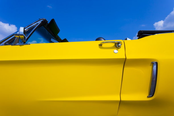 蓝色天空下的黄色复古美国敞篷车图片下载