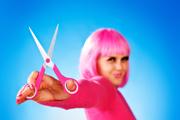 可爱的金发少年戴着令人震惊的粉红色假发，拿着剪刀图片下载