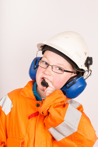 男孩穿着石油工业防护服使用无线电图片下载