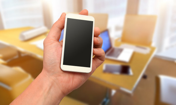 手持智能手机，可定制的空白显示，散焦办公室内图片下载