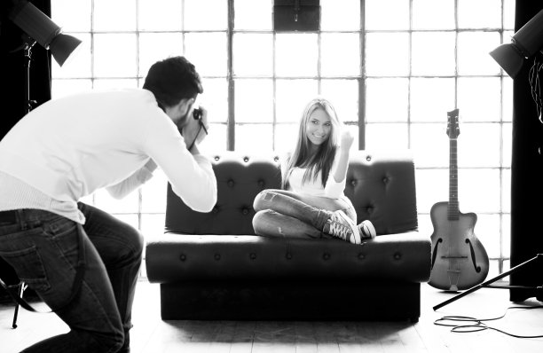 年轻的摄影师在摄影棚拍照图片下载