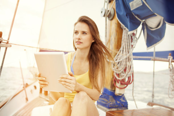 在一艘帆船上用平板电脑的女人图片下载