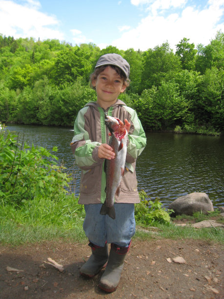 男孩展示他抓到的鳟鱼图片下载