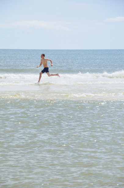 小男孩在沙滩上奔跑图片下载