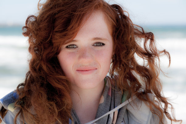 海滩上可爱的红发女孩图片下载