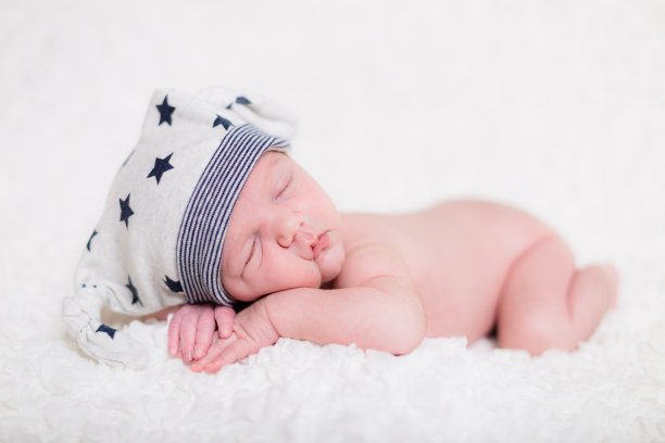 美丽安详地睡在白色毯子上的白种新生儿图片下载