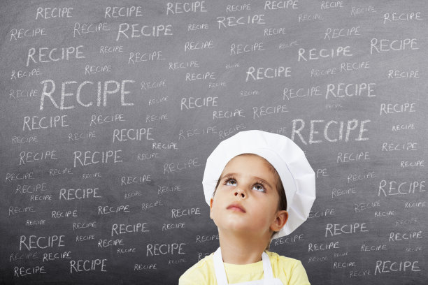 小女孩厨师在黑板上思考食谱图片下载