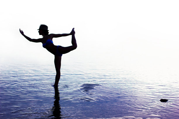 年轻女子在日落海滩做瑜伽图片下载