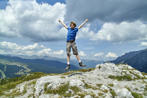 男孩正在山顶上跳图片下载