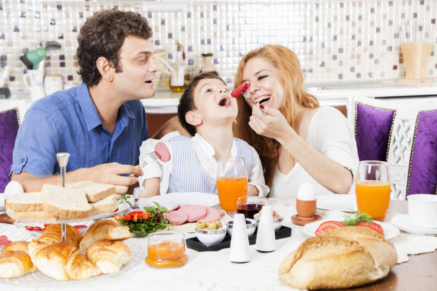 美丽的三口之家享受着晚餐。图片下载