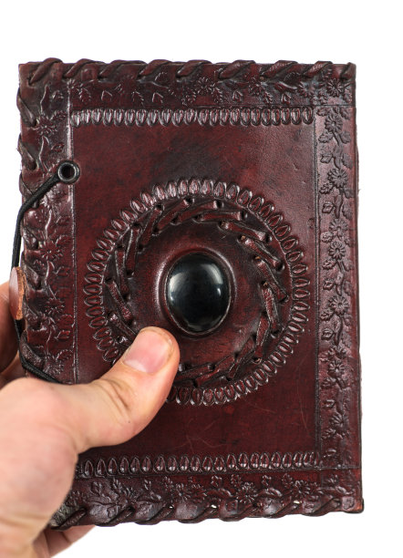 手与棕色的皮革书，日记和笔记本，从印度indisch图片下载