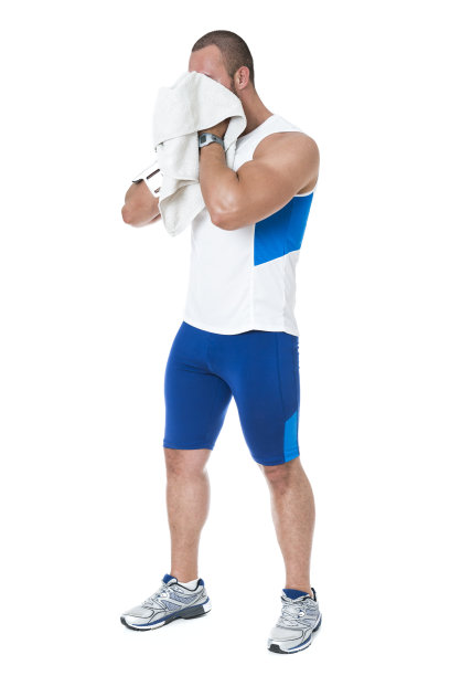 男运动员在运动训练后擦拭脸上的汗水图片下载