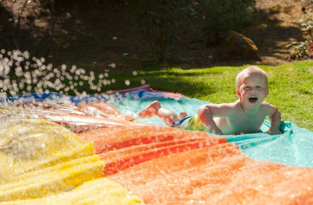 蹒跚学步的孩子在水上滑梯上图片下载