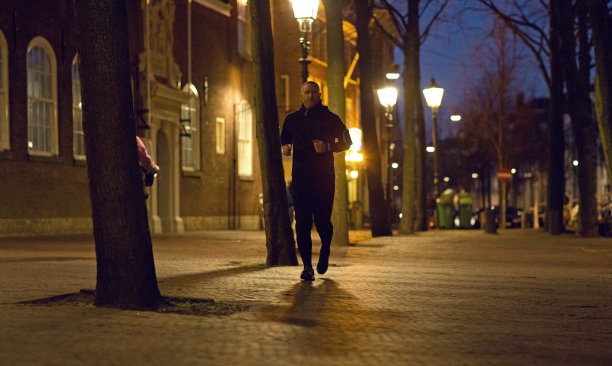 中年慢跑者在傍晚慢跑图片下载