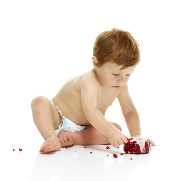 小婴儿在吃他的第一个生日蛋糕图片下载