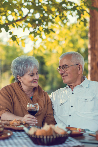 快乐的老夫妇享受在一个户外餐厅和交流。图片下载