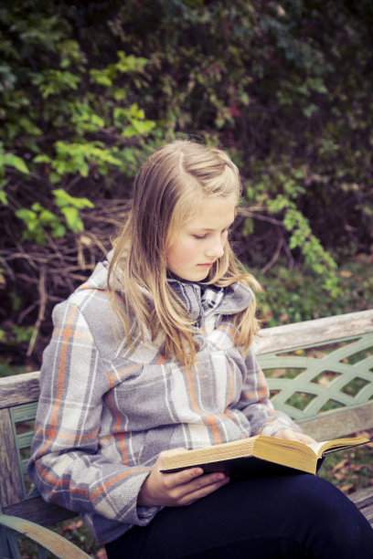 《漂亮女孩在秋天的花园里读书图片下载