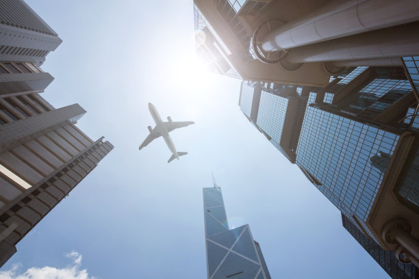 飞机在香港的商务大厦上飞行图片下载