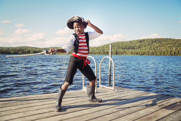 一个非洲裔美国孩子在湖上扮成海盗。图片下载