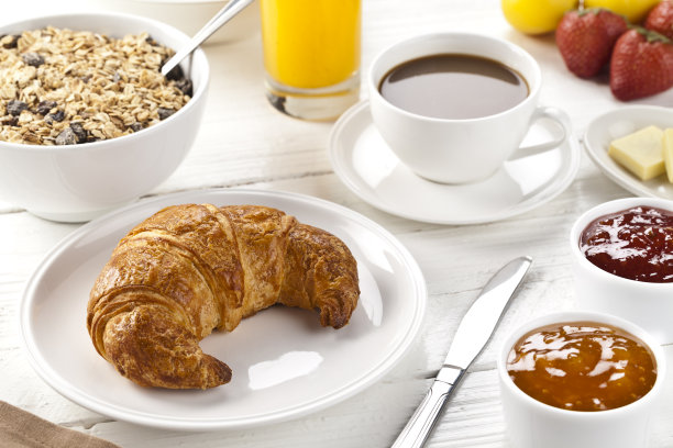 新鲜出炉的羊角面包放在质朴的餐桌上。图片下载