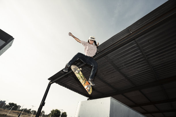 女滑板运动员在城市中跳跃图片下载